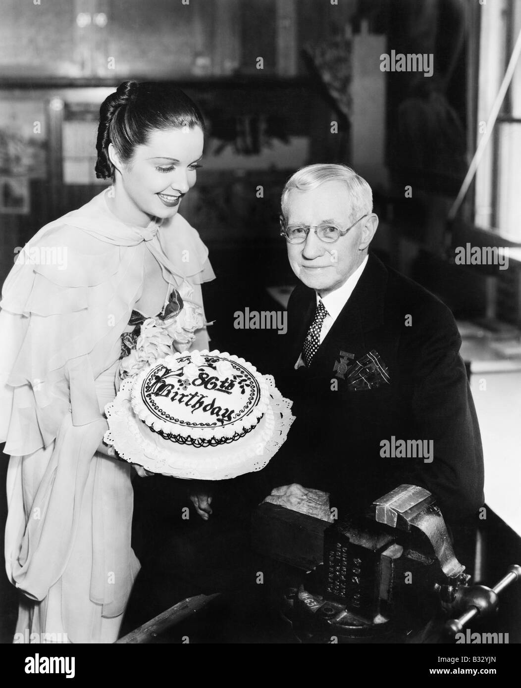 Jeune Femme Presentant Un Gateau D Anniversaire D Un Homme Age Photo Stock Alamy