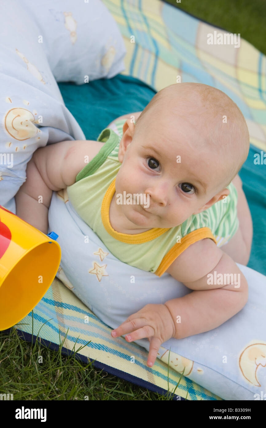 Bébé jouant sur la couverture dans le jardin Banque D'Images