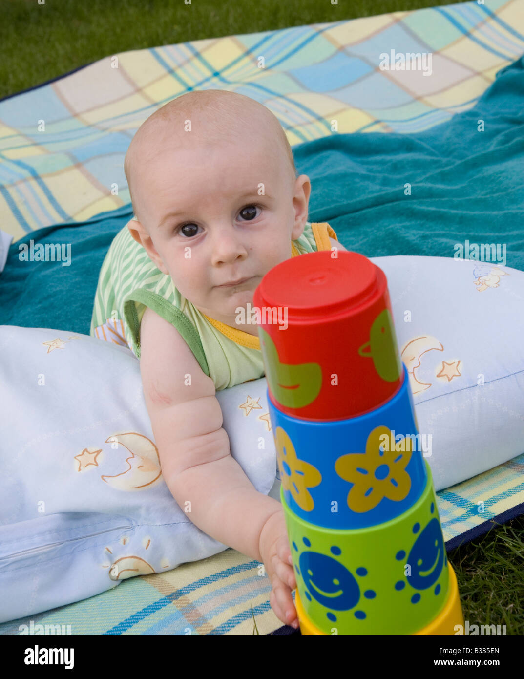 Bébé jouant sur la couverture dans le jardin Banque D'Images