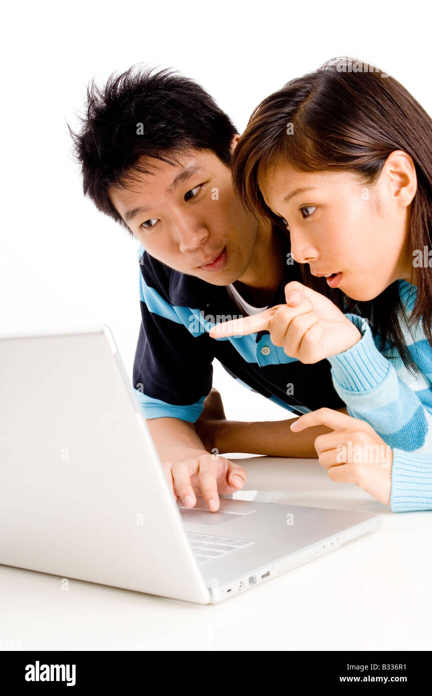 Une jeune femme asiatique points à l'écran de l'ordinateur portable Banque D'Images