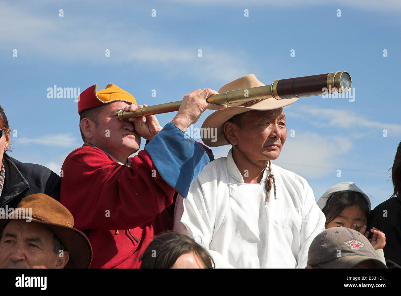Un vieil homme mongol profitant de la journée des courses de chevaux à l'aide d'un télescope dans le cadre du Festival Naadam en Mongolie. Banque D'Images