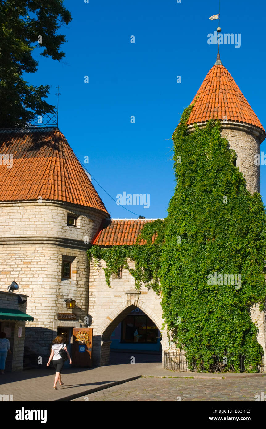 Femme marche de la vieille ville par la porte en Varav Viru Tallinn Estonie Europe Banque D'Images