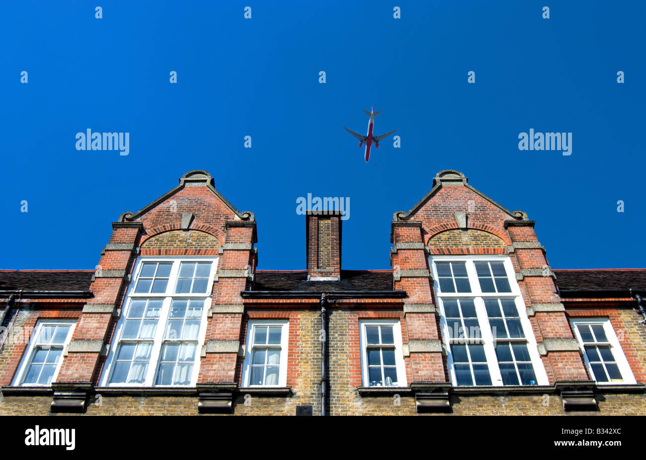 Un avion survole une école victorienne à Putney, Londres, Angleterre du Sud-Ouest Banque D'Images