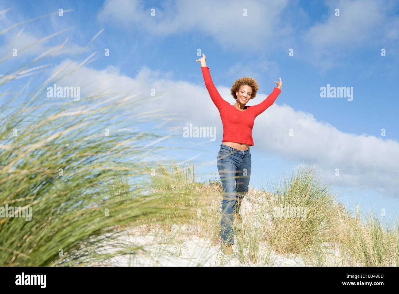 Jeune femme posant sur une colline de sable Banque D'Images