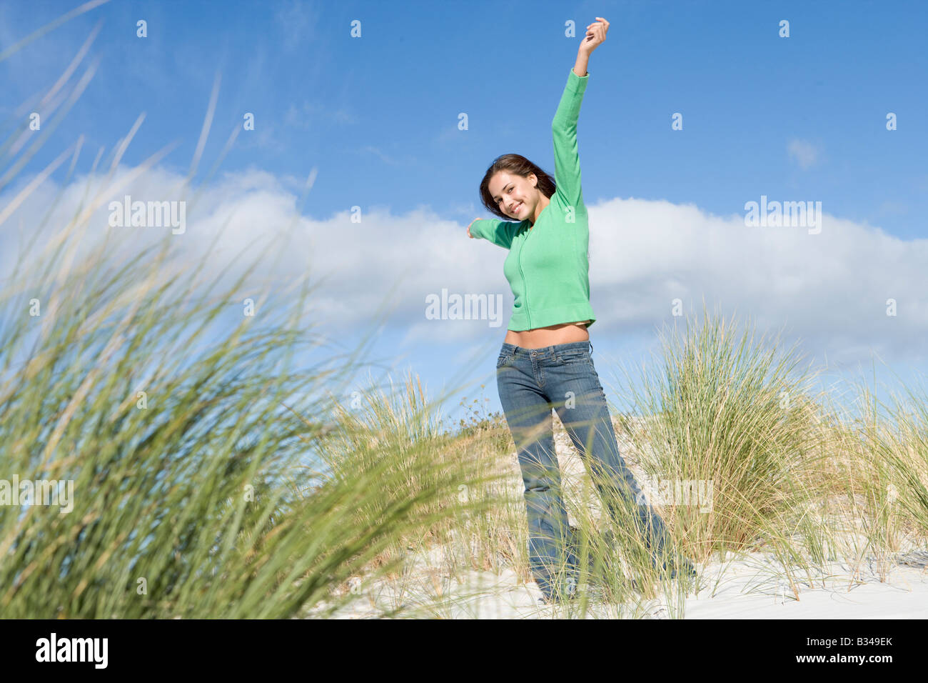 Jeune femme posant sur une colline de sable Banque D'Images