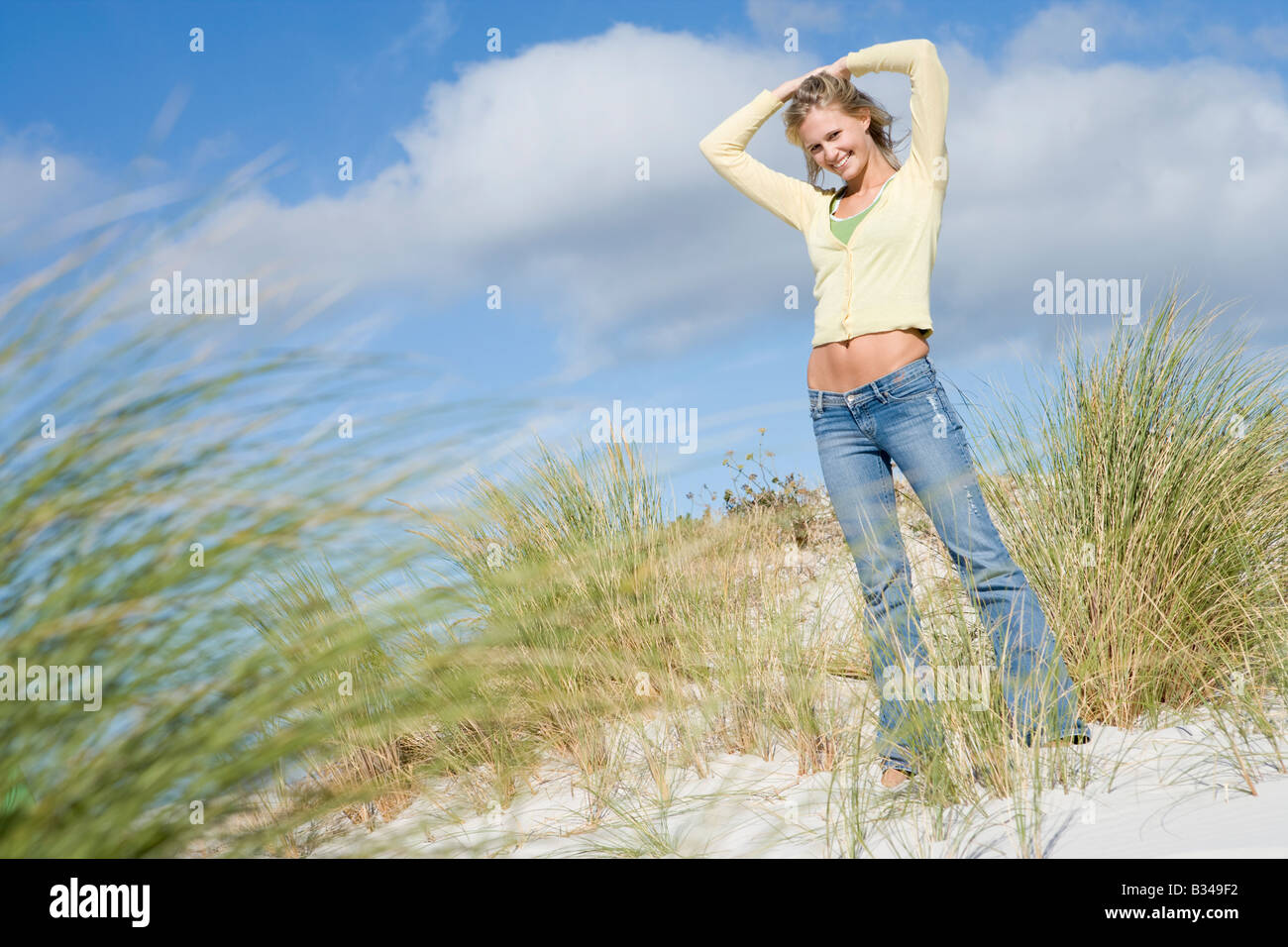 Jeune femme posant sur une colline de sable Banque D'Images