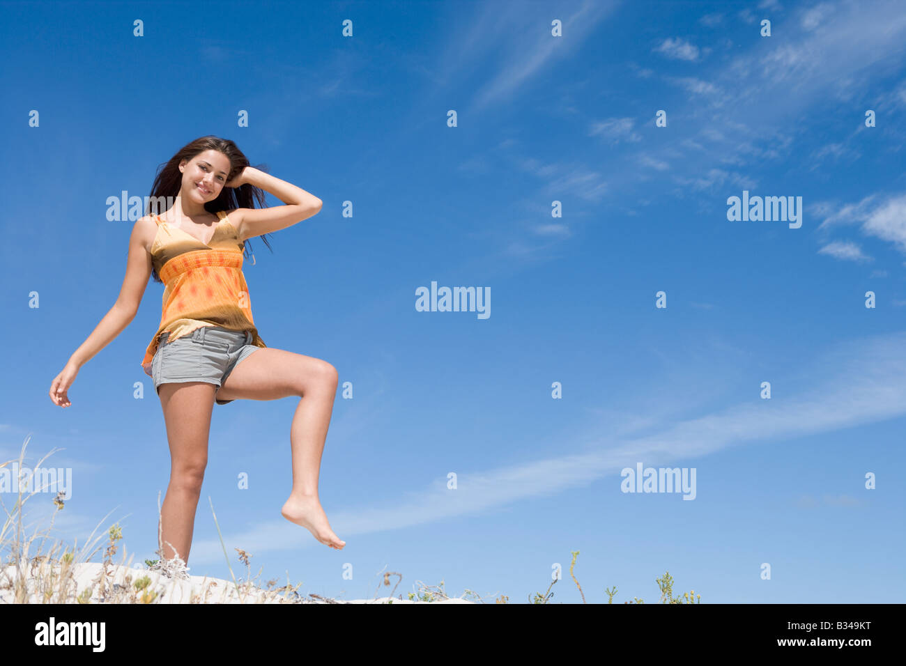 Jeune femme posant sur une colline de sable Banque D'Images