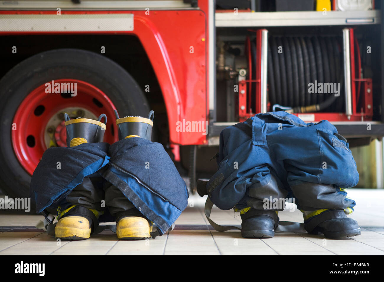 Deux uniformes de pompier sur marbre par fire engine Banque D'Images