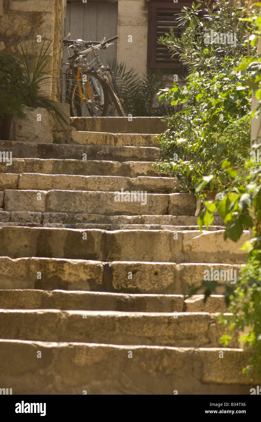 Les vélos en haut de l'escalier de pierre dans les ruelles de Hvar Croatie Banque D'Images