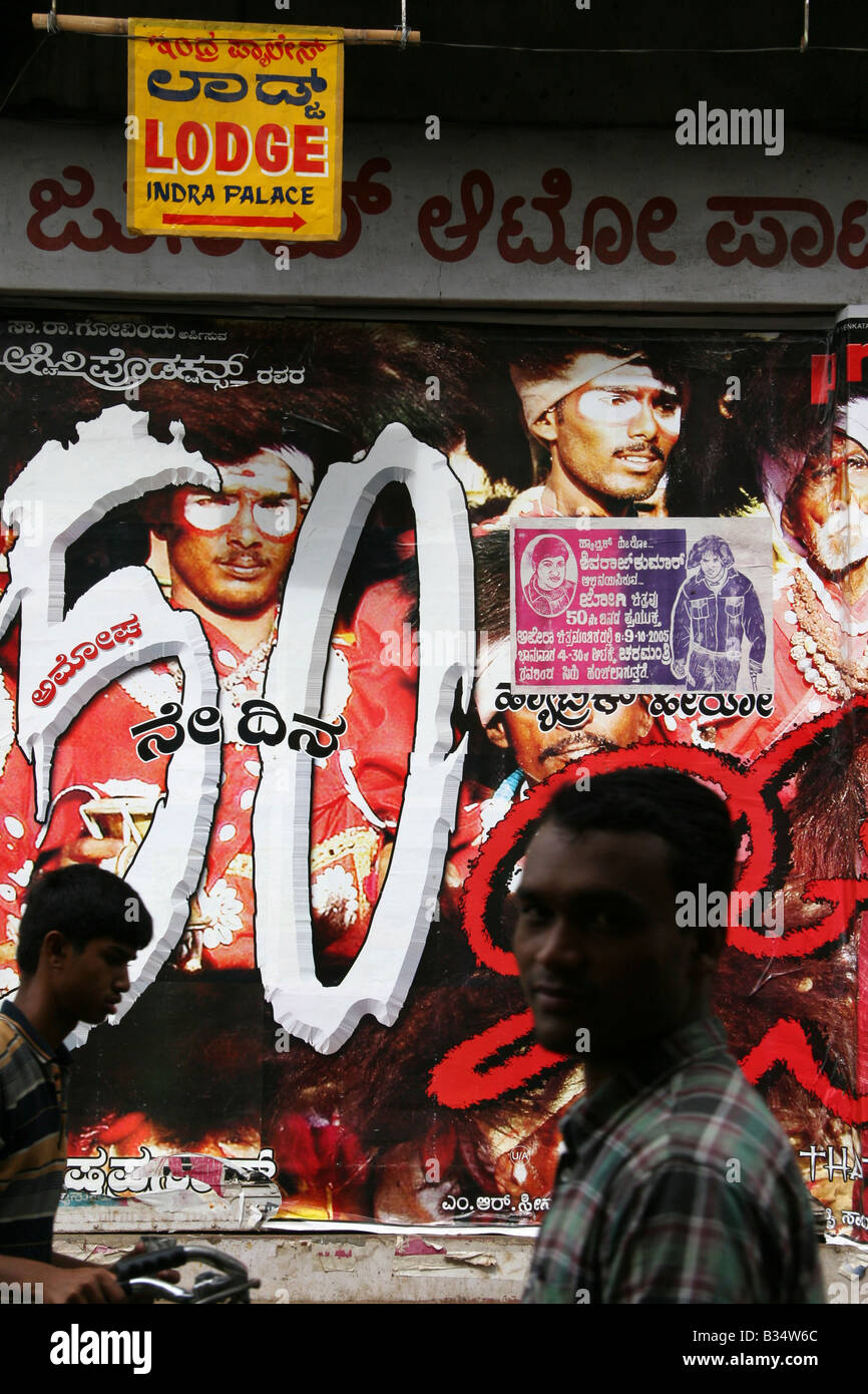 Un homme passe devant une affiche de film à Mysore, Inde. Pour les films Bollywood et autres films régionaux ajouter de la couleur à des rues. Banque D'Images