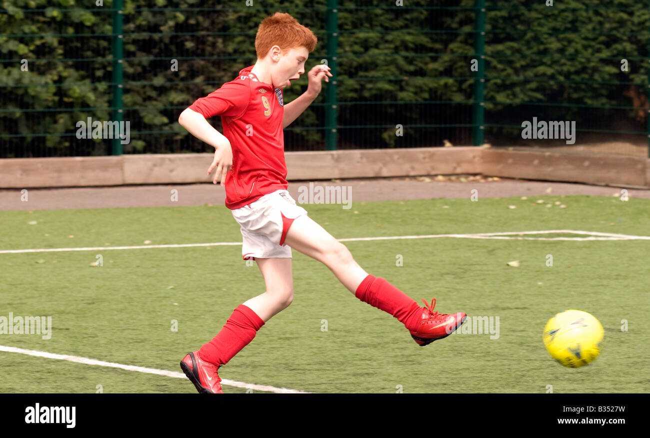 Garçon de 11 ans à jouer au football, Maida Vale, à Londres, Royaume-Uni. Banque D'Images