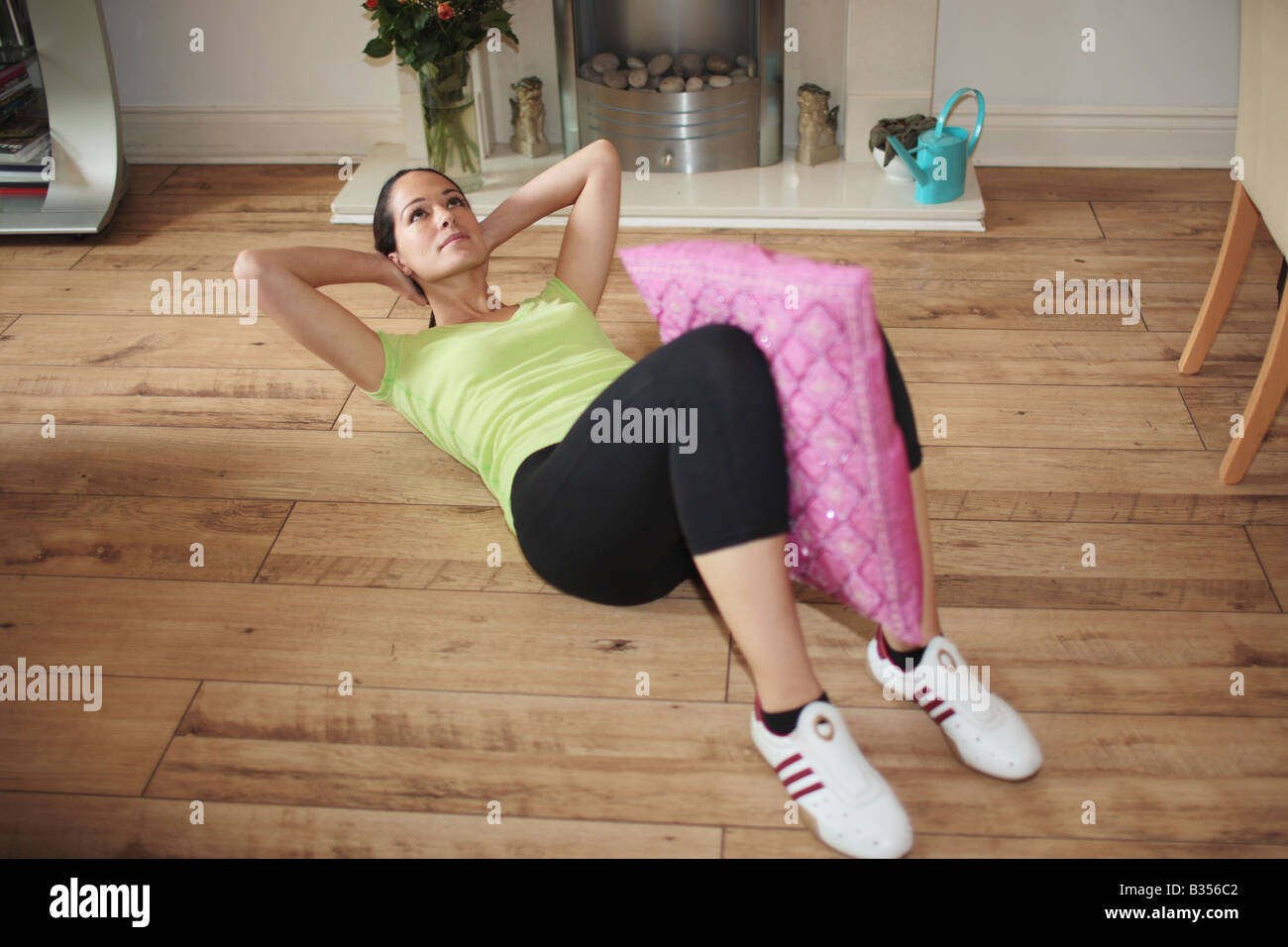 Young Woman Doing Sit Ups avec modèle coussin publié Banque D'Images