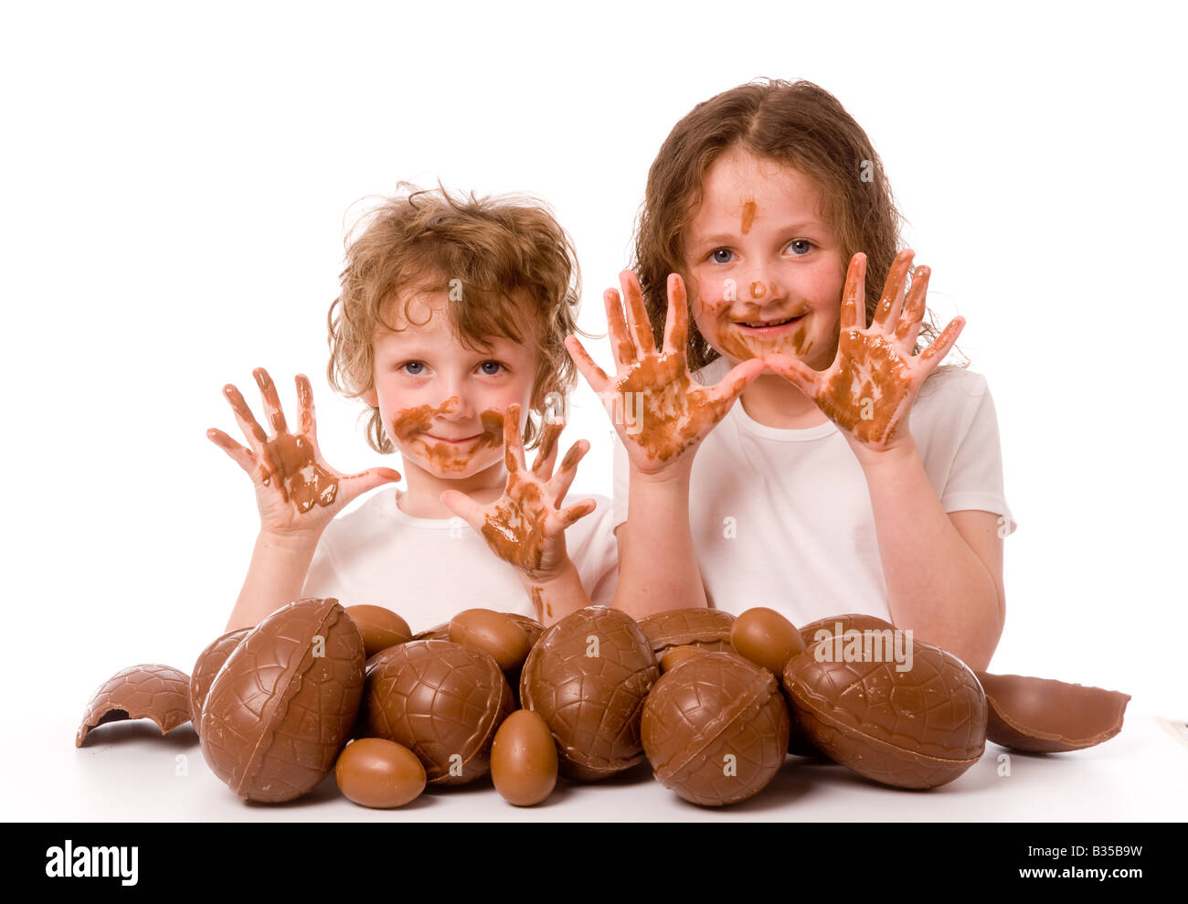 2 jeunes enfants avec pile d'oeufs de pâques montrant des mains désordonnées Banque D'Images