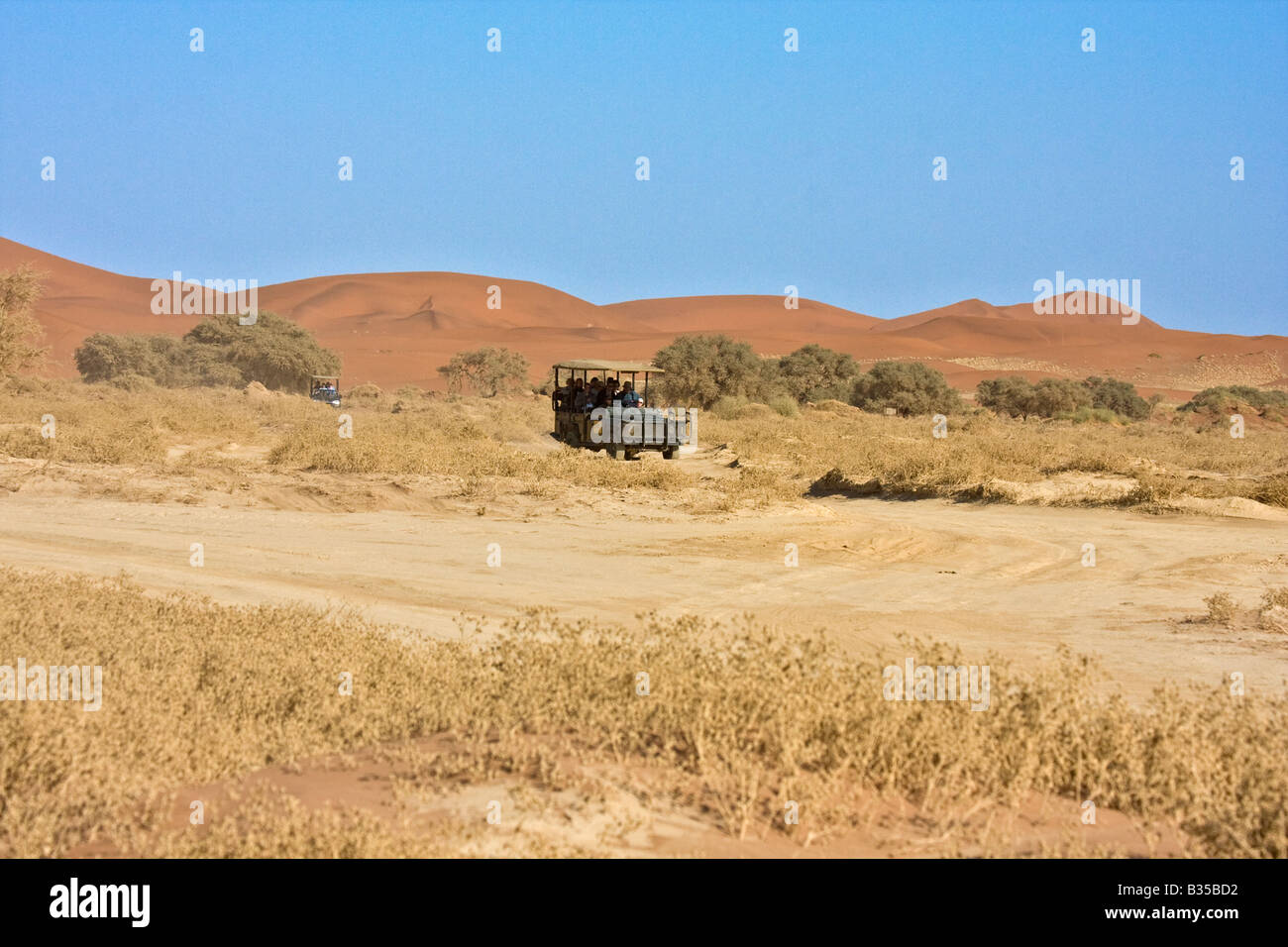 Les visiteurs dans les véhicules de safari voyage à travers les dunes de sable de Sossusvlei zone de dunes de sable, dans le centre sud de la Namibie. Banque D'Images