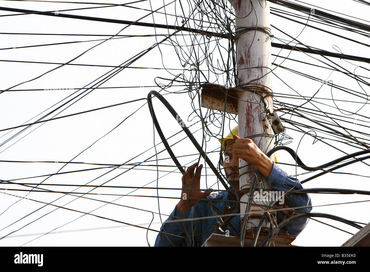 Homme réparation des lignes téléphoniques, Hanoi, Vietnam Banque D'Images