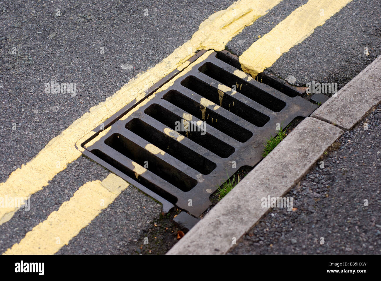Couvercle du trou de vidange et doubles lignes jaunes UK Banque D'Images