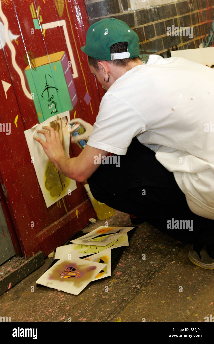 Artiste de rue à l'aide de pochoirs et de peinture en aérosol à Banksy's 2008 Cans Festival à Londres, Leake Street Banque D'Images