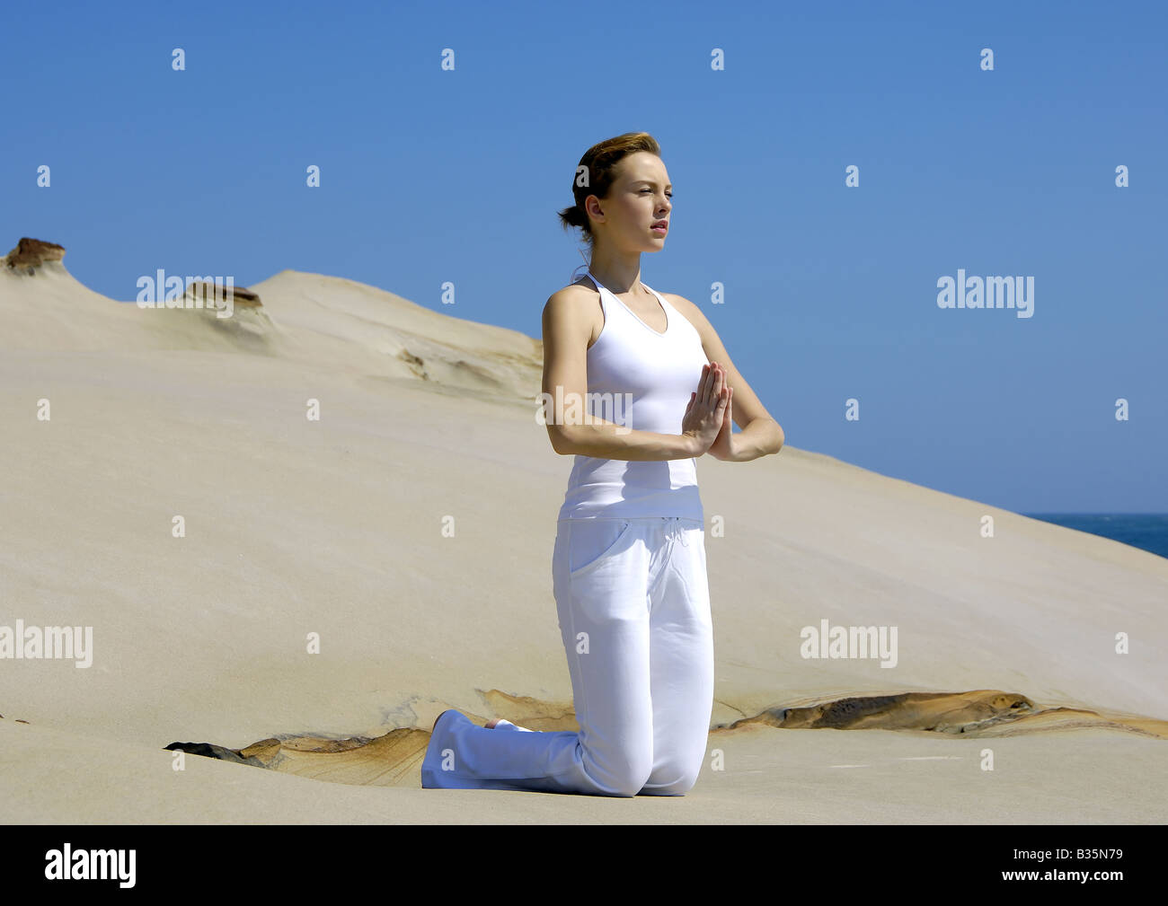 Jeune femme pratiquant le yoga dans une position de prière Banque D'Images