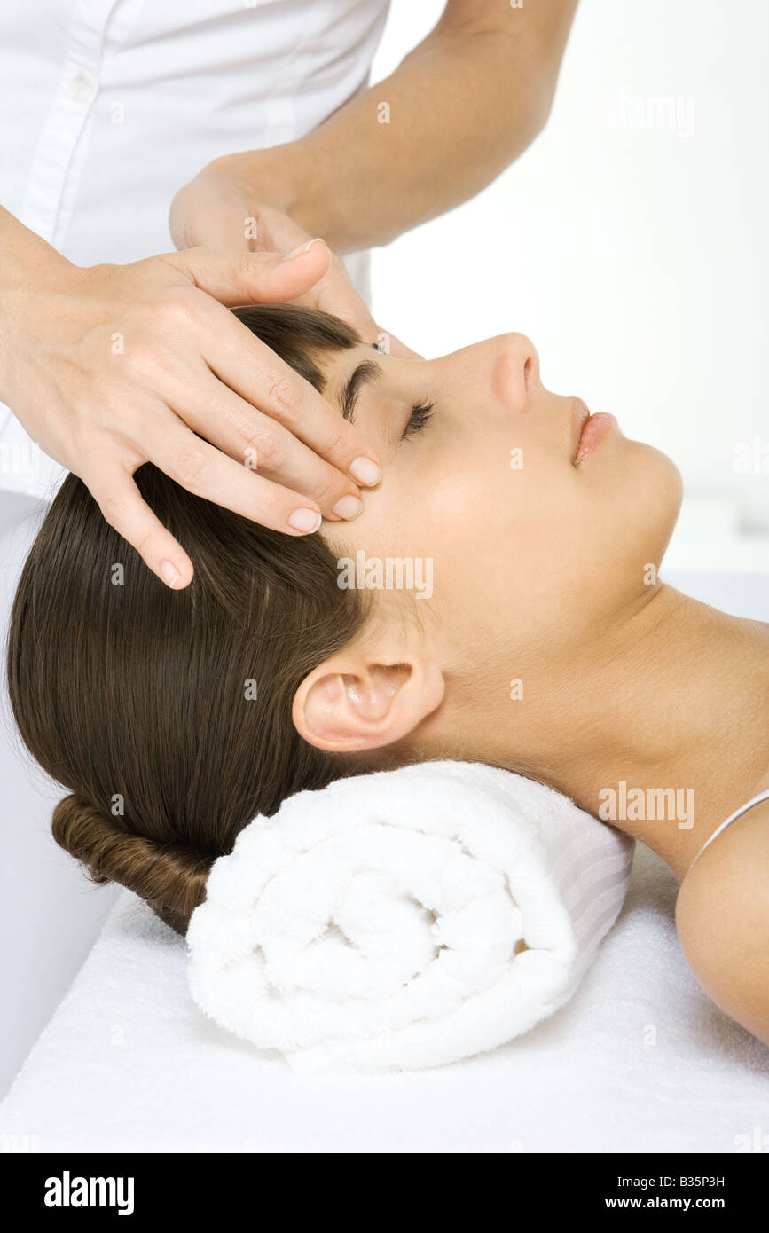 Woman receiving massage de la tête, couché avec les yeux fermés, cropped view Banque D'Images