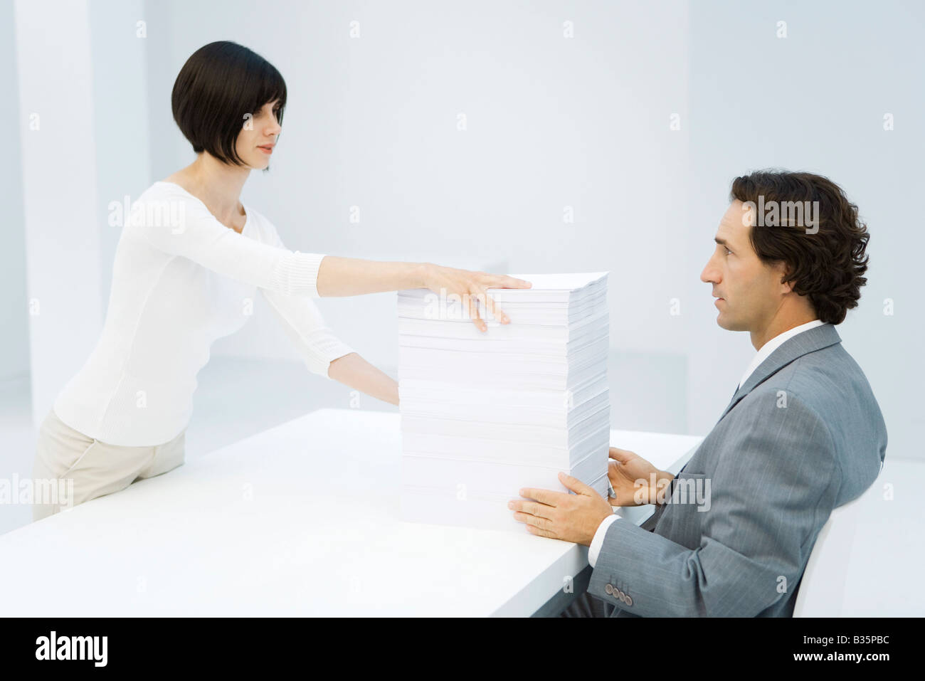Femme et homme d'échange professionnel grande pile de papier dans votre bureau Banque D'Images