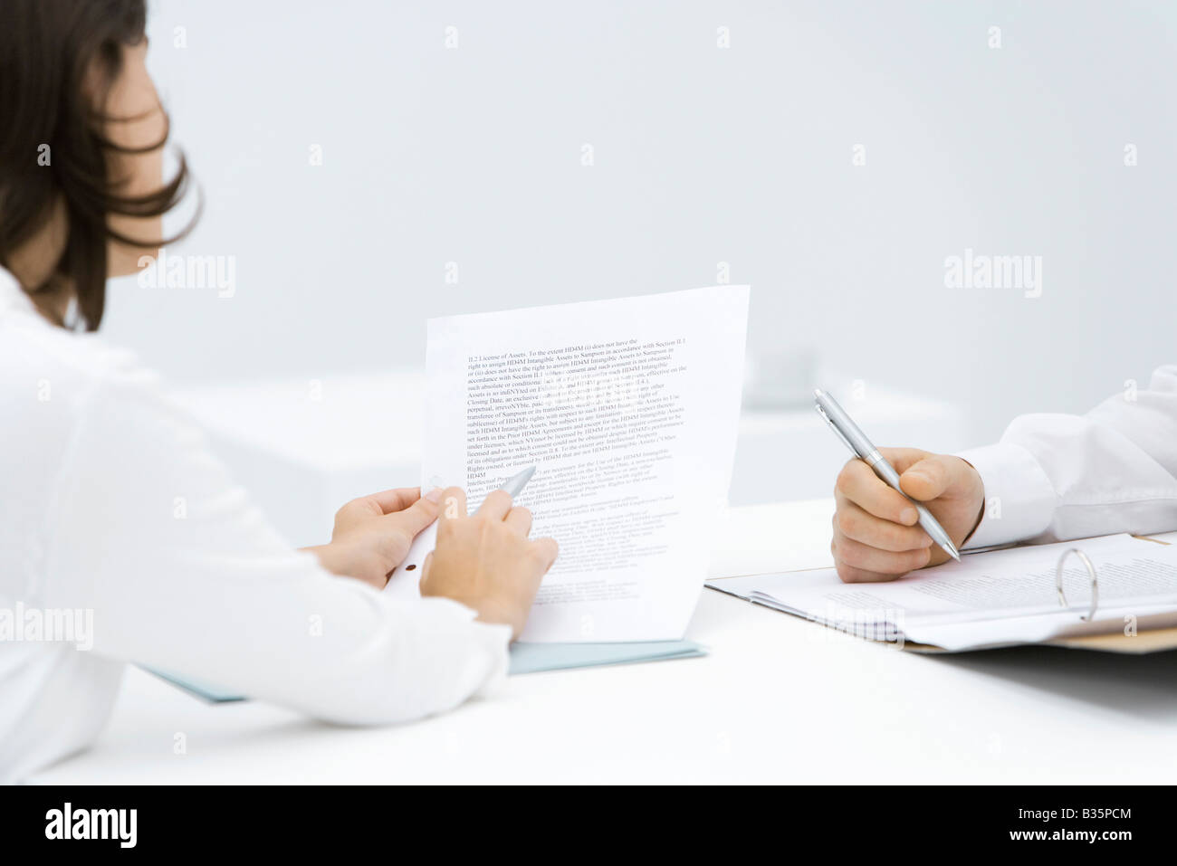 L'examen de la femme, l'homme du contrat modifier le document dans la reliure, cropped view Banque D'Images