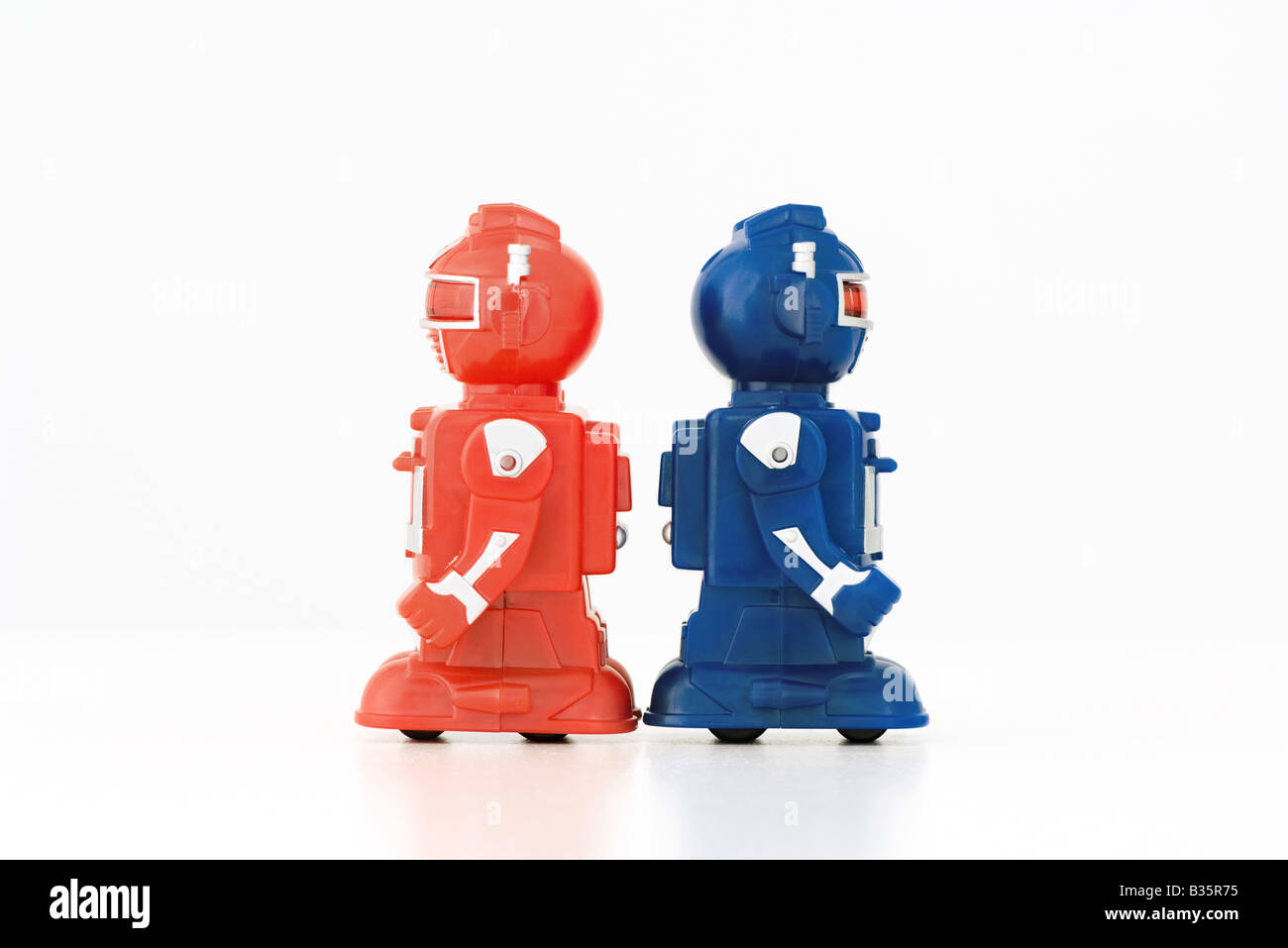 Robots Jouets standing back to back, side view Banque D'Images