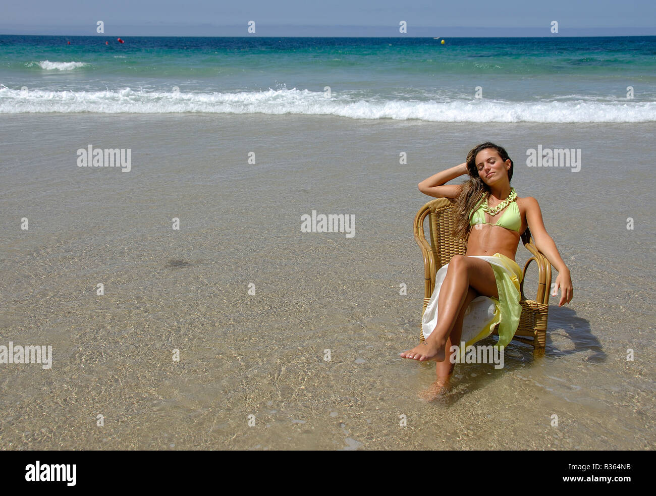 Girl sitting in Chair dans la jeune femme de détente mer bikini de longs cheveux blonds vagues sables d 'emmenez-moi' voyage d'image Banque D'Images