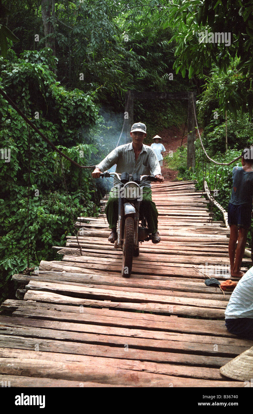 Une moto débit sur un pont en bois fragile au Vietnam Banque D'Images