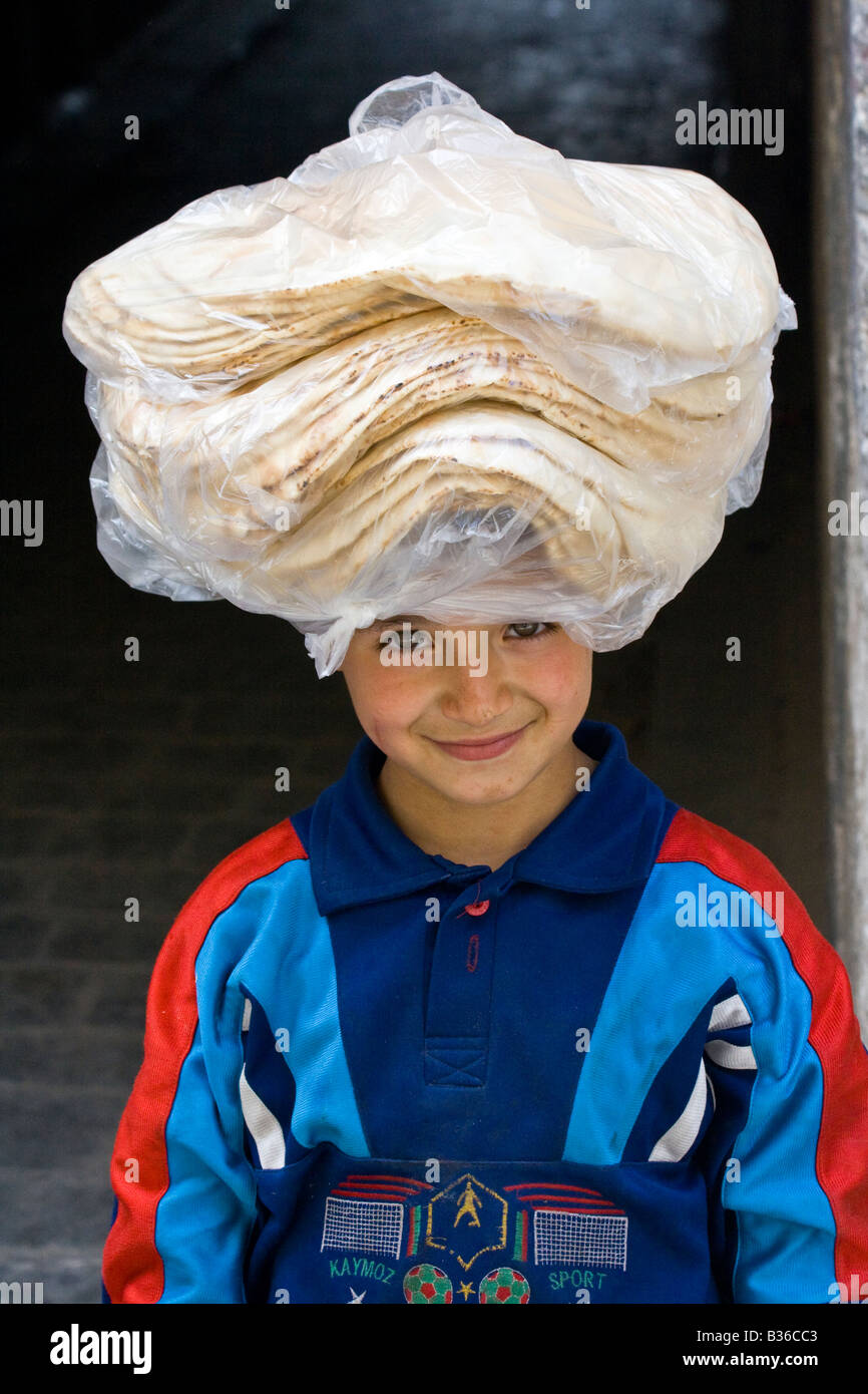République Boy carrying Pain frais sur sa tête dans la vieille ville d'Alep en Syrie Banque D'Images