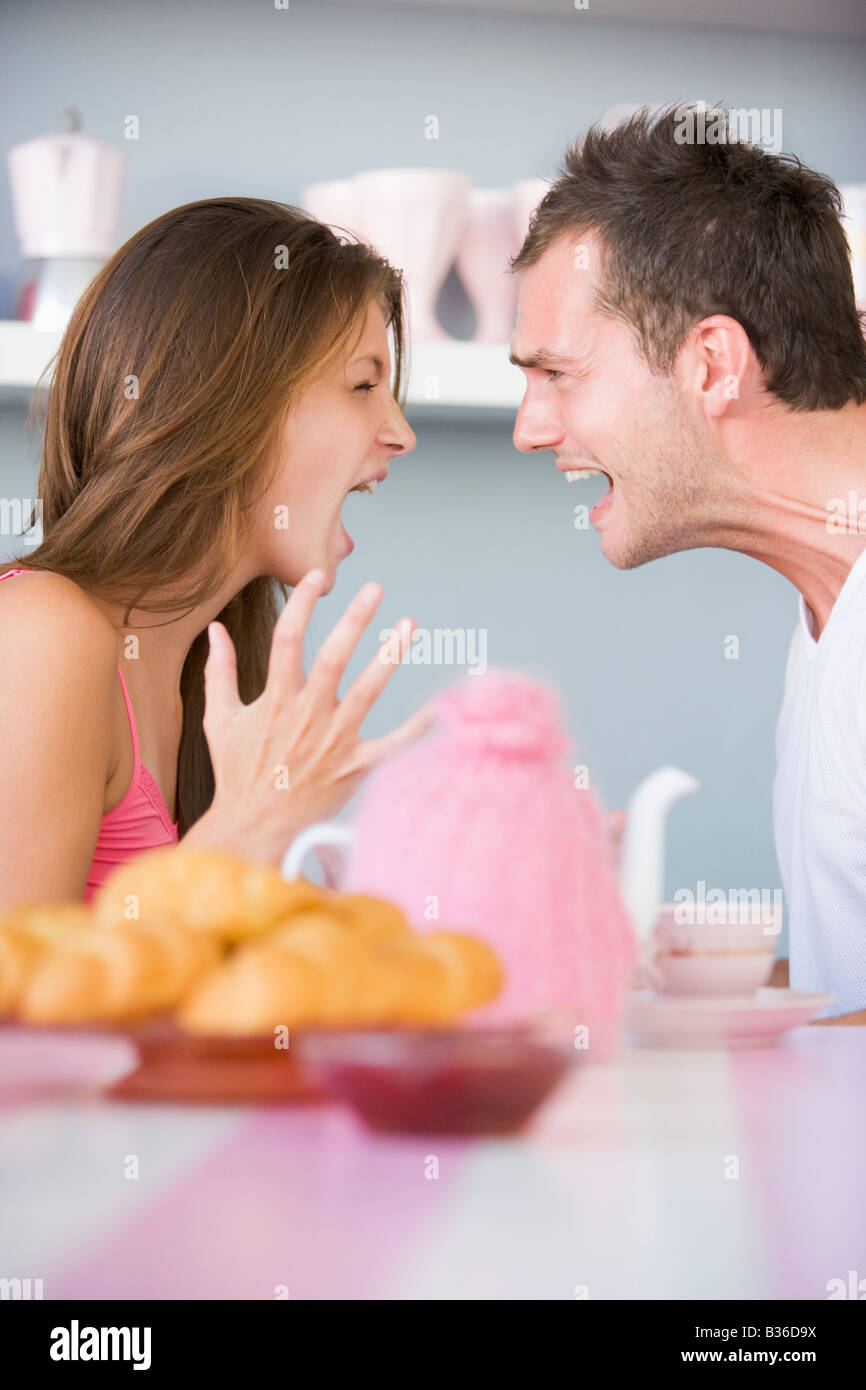 Jeune couple assis à une table en faisant valoir Banque D'Images