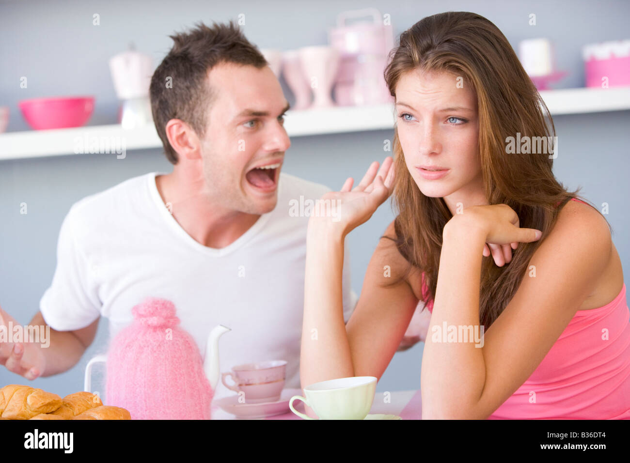 Jeune couple assis à une table en faisant valoir Banque D'Images
