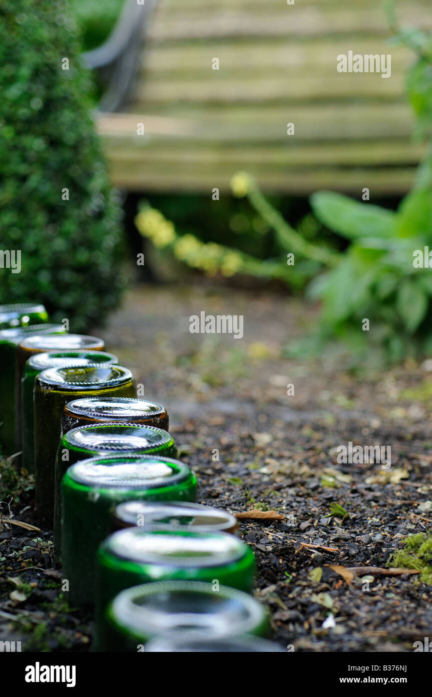 Bouteilles utilisées comme voie d'bordure dans un jardin urbain chemin menant à Norfolk UK siège de jardin Banque D'Images