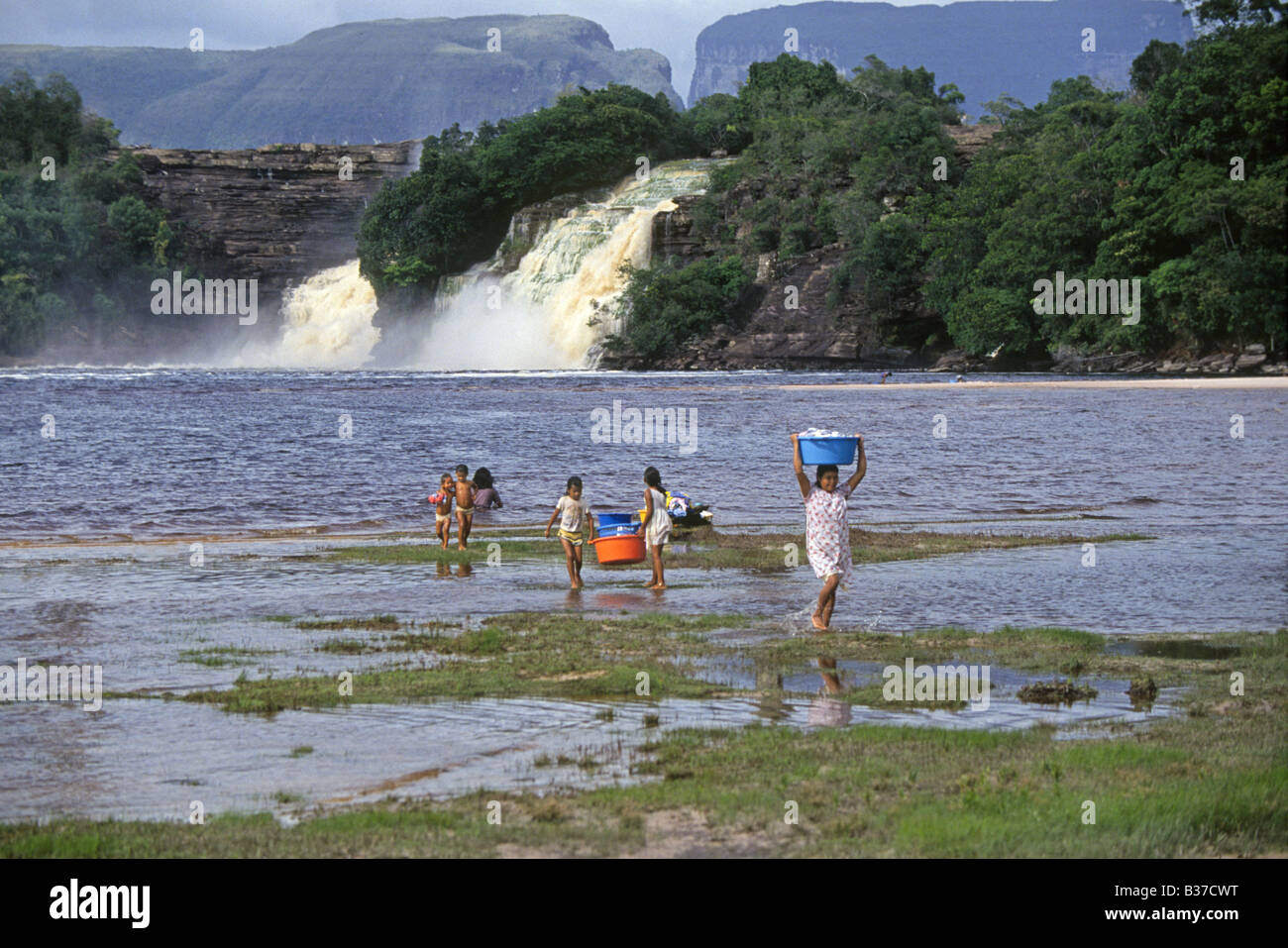 Les femmes indiennes Pemon lavez les vêtements à la main dans un lac près d'une grande cascade dans le Parc national Canaima Banque D'Images
