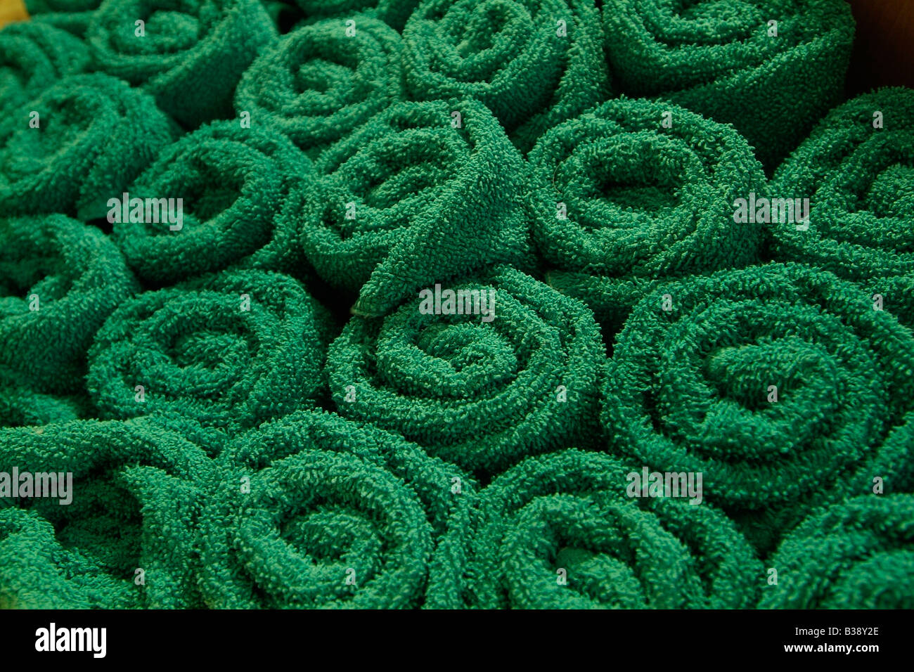 Les rouleaux de serviettes vert empilées dans un salon de coiffure Banque D'Images