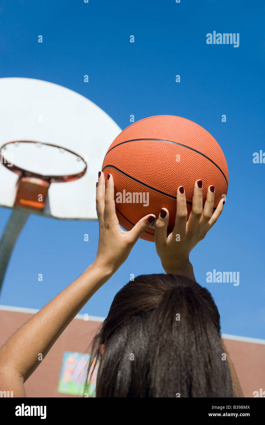Une jeune femme jetant une basket-ball. Banque D'Images