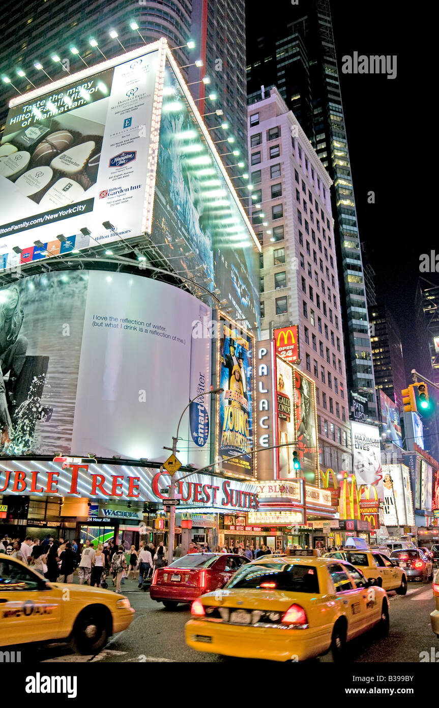 NEW YORK CITY, New York, États-Unis — Une scène nocturne animée de Times Square, l'intersection emblématique de Midtown Manhattan, déborde d'activité. Les taxis jaunes naviguent à travers les rues bondées, leur couleur distinctive se démarquant sur la toile de fond des panneaux lumineux au néon, des panneaux d'affichage massifs, et des écrans LED. Des foules de piétons, touristes et habitants, remplissent les trottoirs et les passages, incarnant l'énergie de «la ville qui ne dort jamais». Banque D'Images