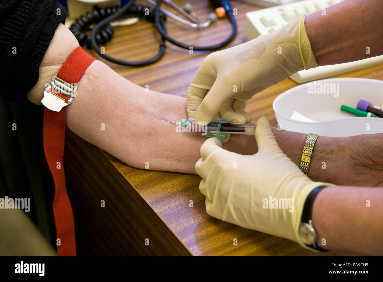 Femme ayant une prise de sang pour sang par des infirmières en cabinet médical. Banque D'Images