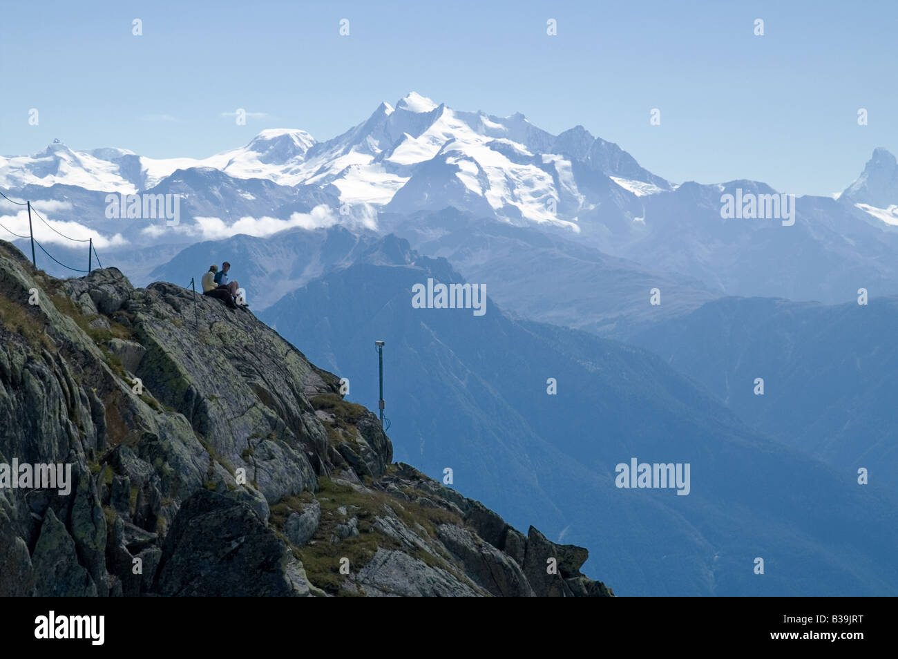 Deux randonneurs ont une pause avec le Dom (4545 m) en arrière-plan Banque D'Images