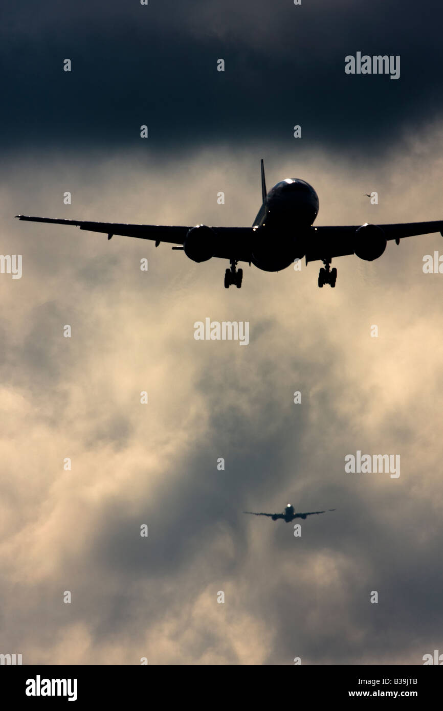 Les avions de la queue à la terre tandis que les formes de turbulence de sillage derrière . L'aéroport Heathrow de Londres, UK Banque D'Images