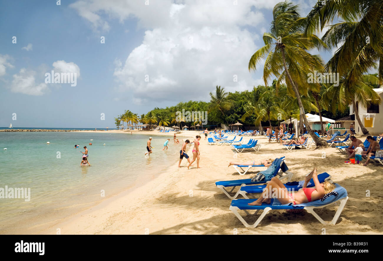 Les gens en train de bronzer sur une plage de vacances, lieux de l'hôtel Windjammer Landing, Sainte-Lucie, Caraïbes Banque D'Images
