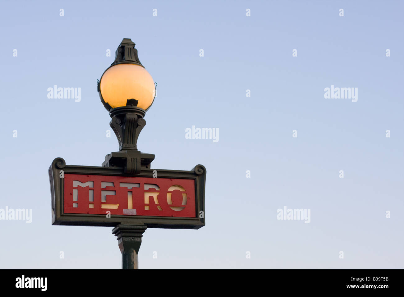 Un éclairage magnifique signe métro Parisien dans le style art nouveau tourné au crépuscule contre un ciel bleu clair et brillant de l'intérieur. Banque D'Images