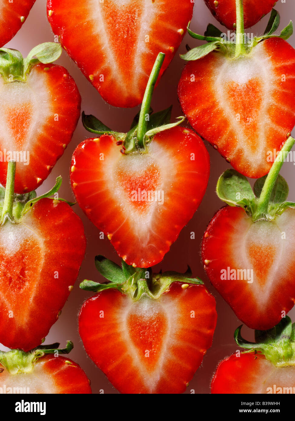 Coupe de fraises biologiques en forme de cœur stylisé , concept créatif photo représentant un cœur en bonne santé, sur un fond blanc. Banque D'Images