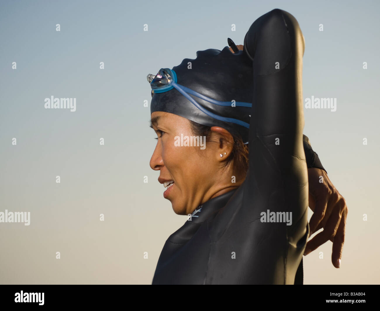 Asian woman stretching en combinaison et lunettes Banque D'Images
