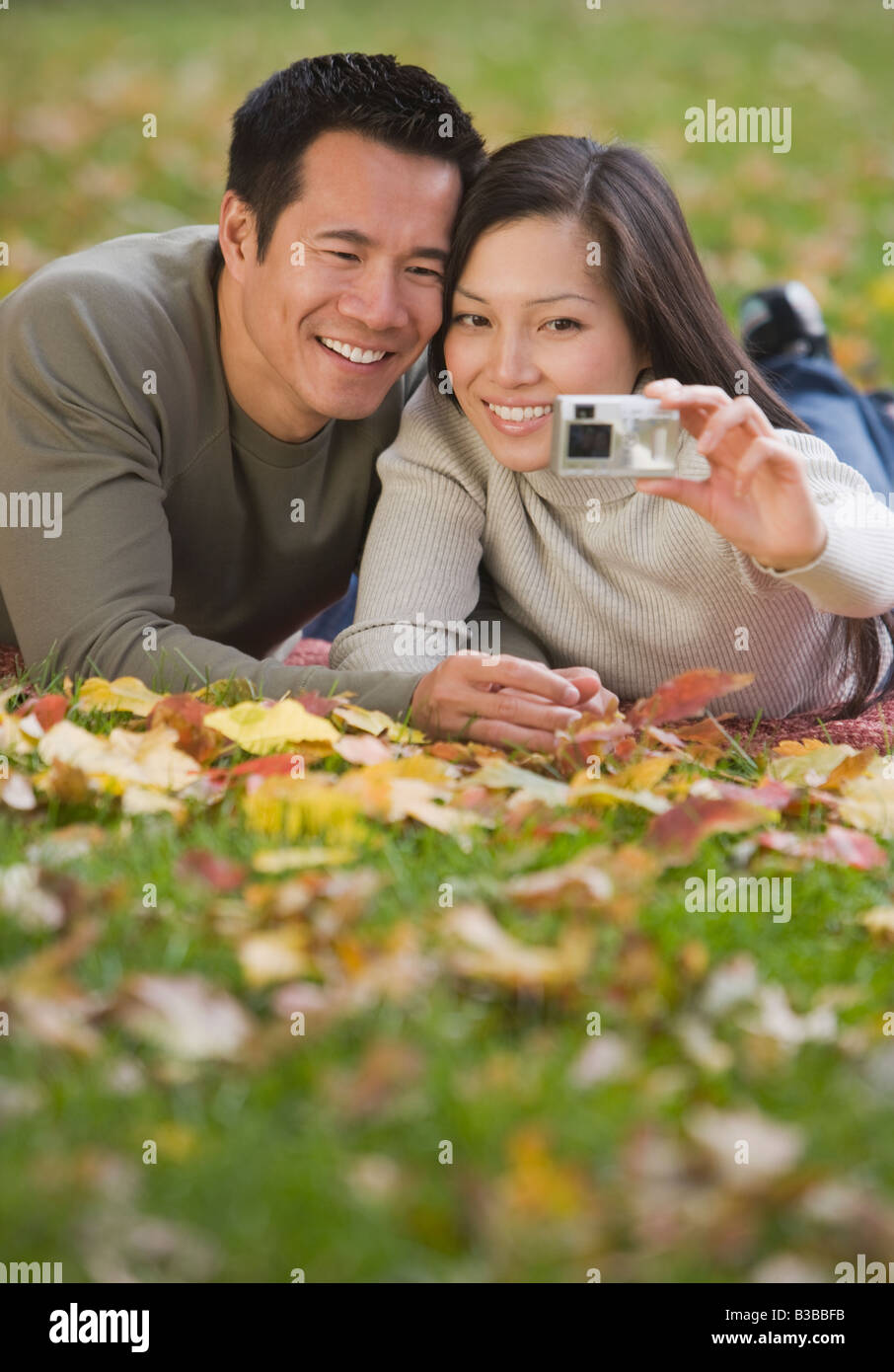 Asian couple taking own photograph Banque D'Images