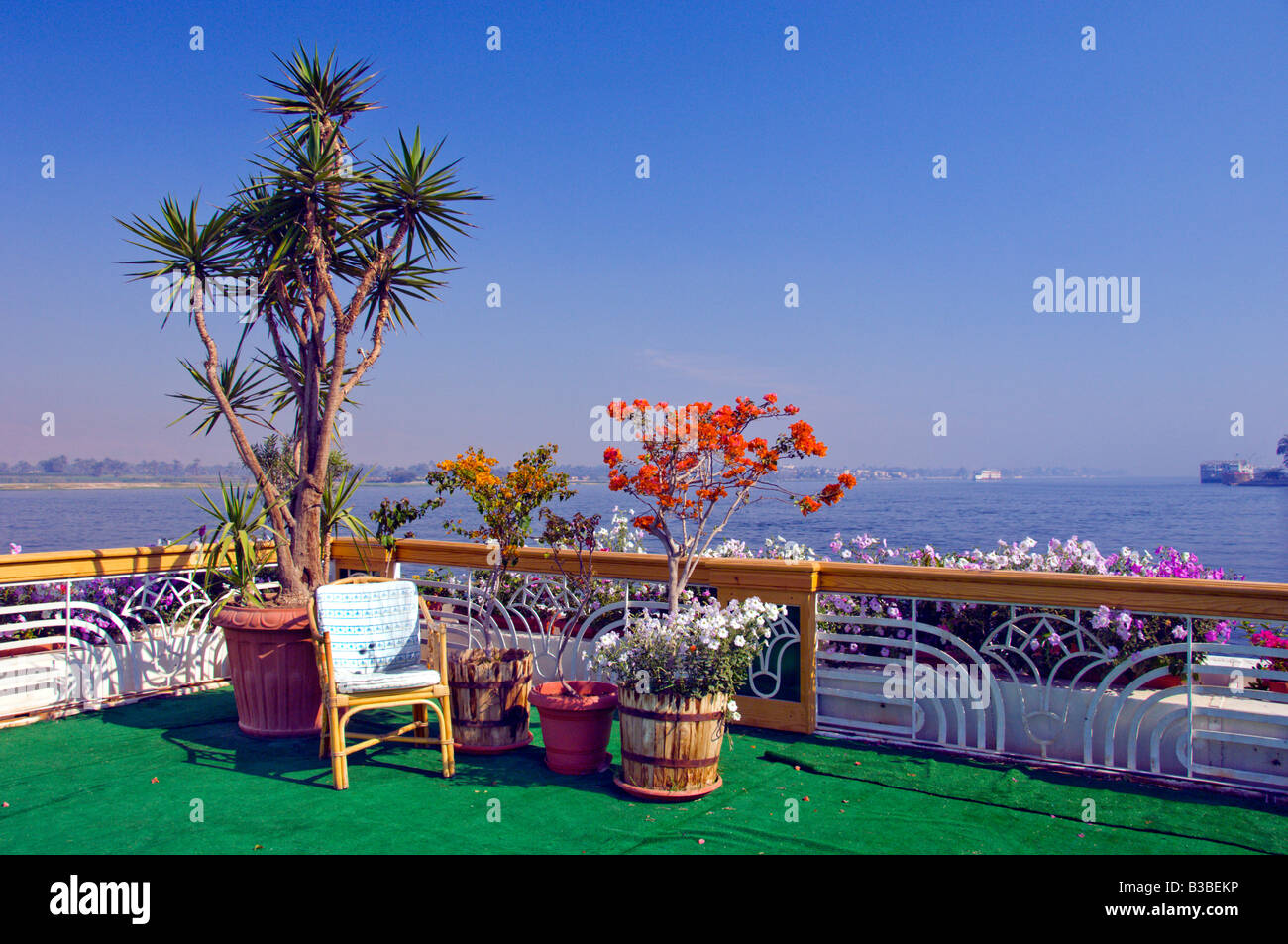 Un patio avec des fleurs tropicales surplombant le Nil à l'hôtel Sonesta St George à Louxor Egypte Banque D'Images