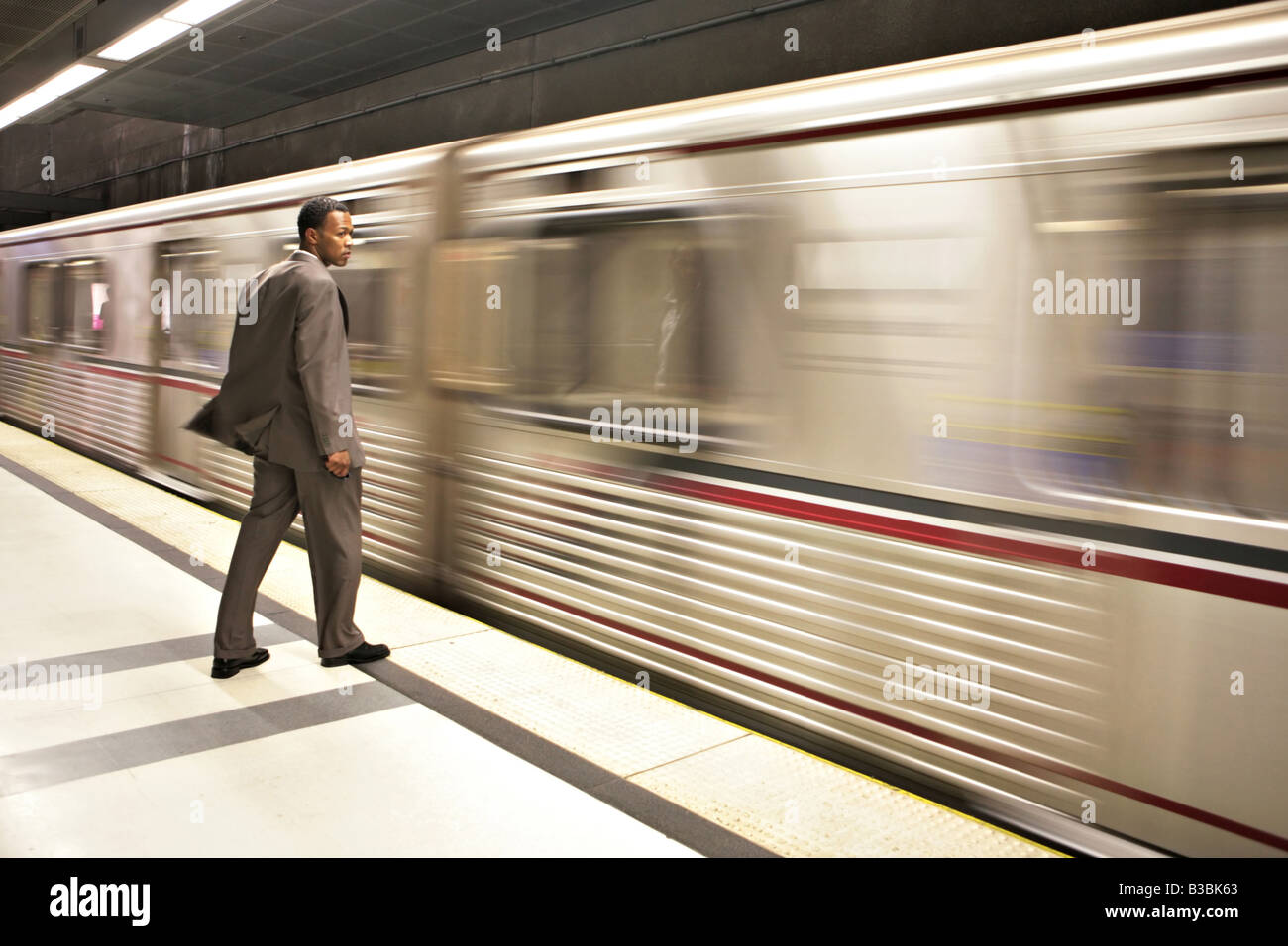 Business Man Watching le métro passer par l'effet de flou intentionnel de l'image est en haute ISO Banque D'Images