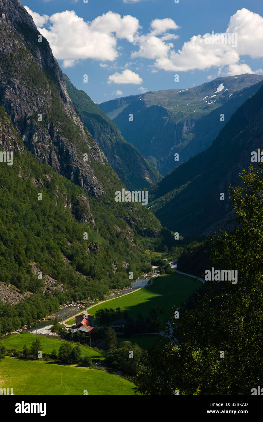Couleur vert magnifique panoramique vertical vallée norvégienne à Fjaerland près de Flam Norvège avec ruisseau de montagne et cascade lointain, ciel bleu Banque D'Images