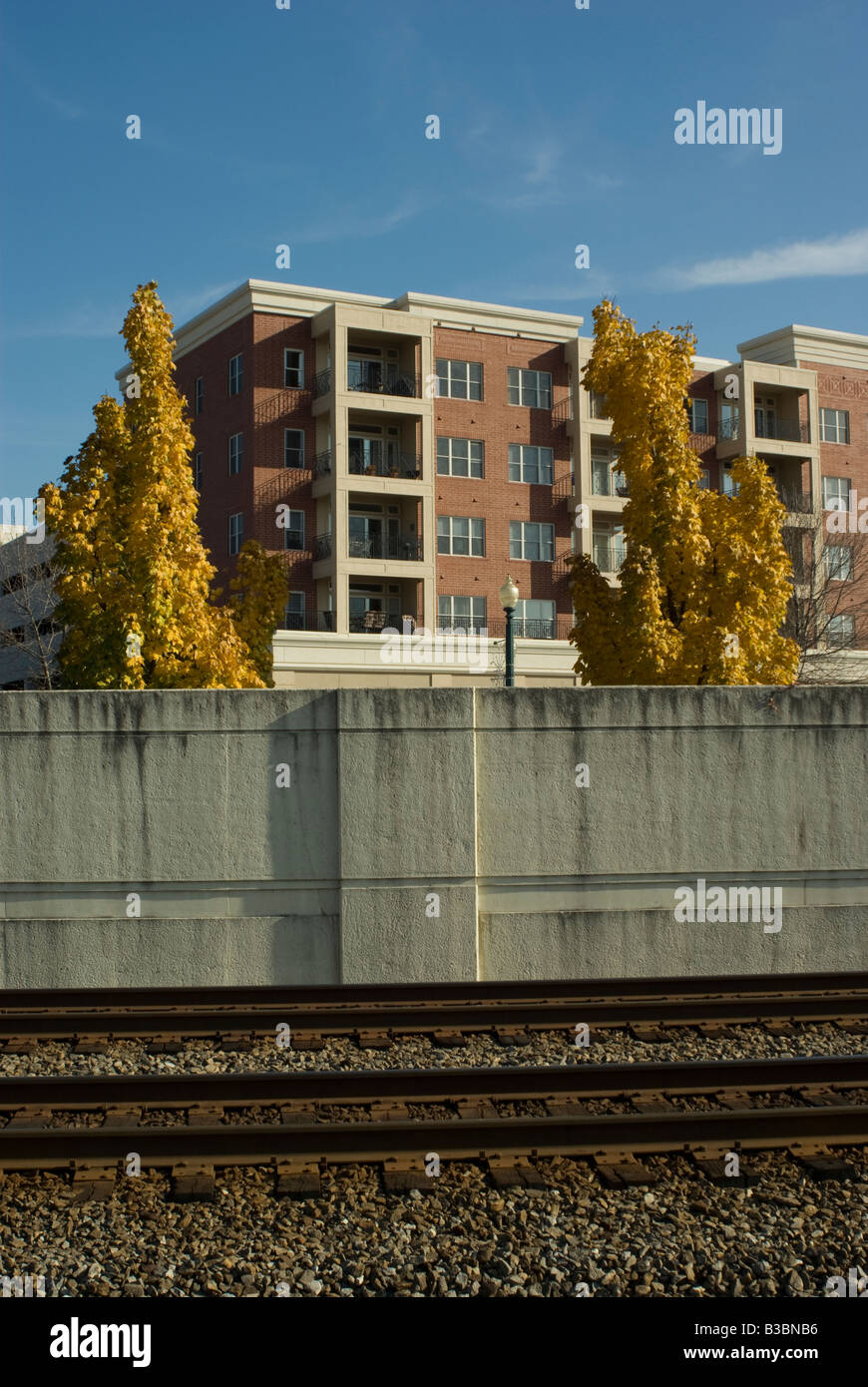 Couleurs d'automne sont derrière ce mur bloquant son chemin de fer avec la construction d'appartements récents dans l'arrière-plan Banque D'Images