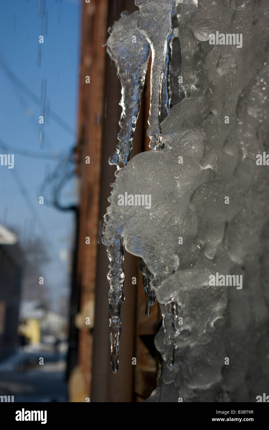 Les glaçons pendre du côté d'un immeuble après une tempête de glace Banque D'Images