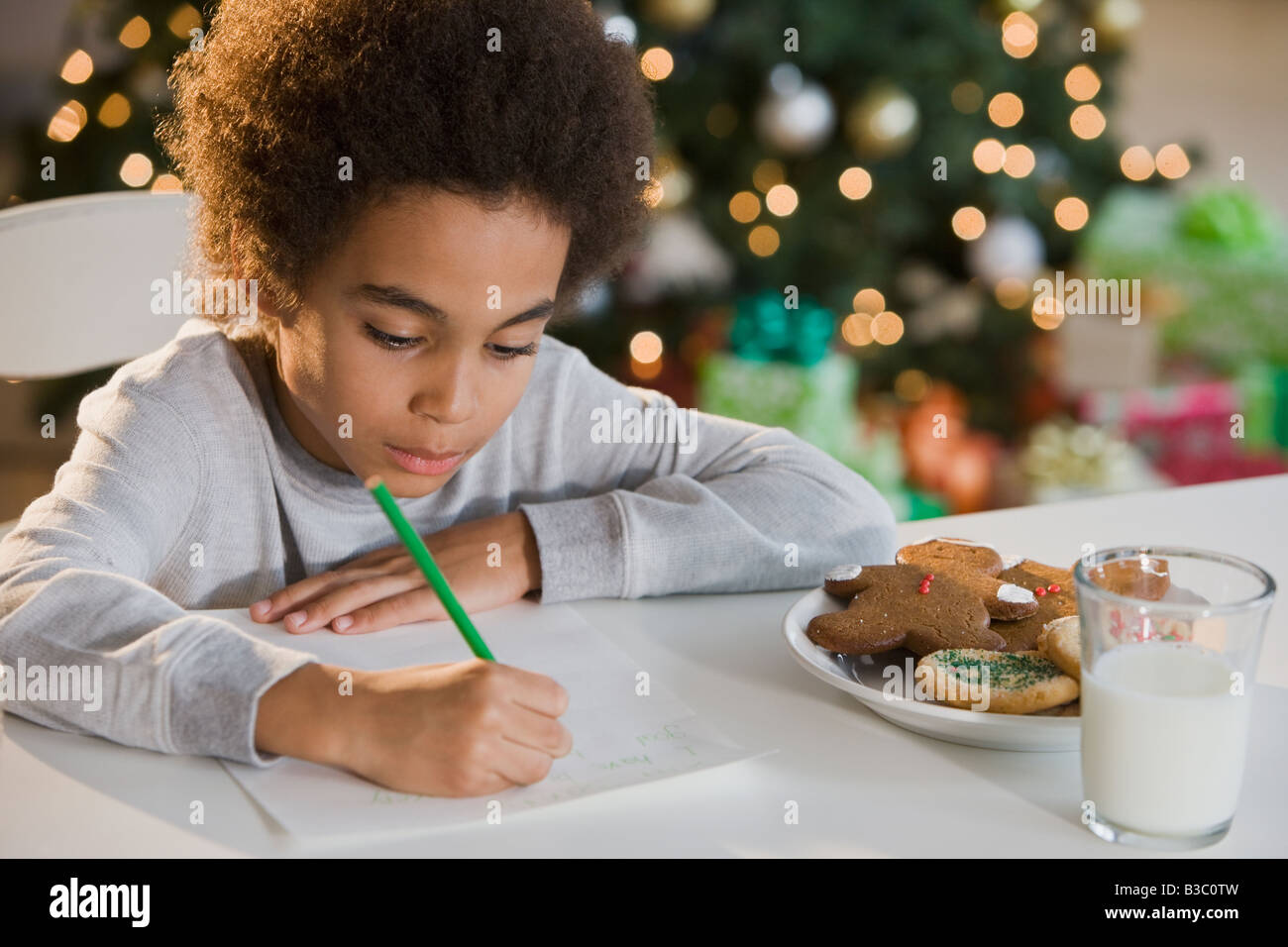 Mixed Race boy écrit une lettre au Père Noël Banque D'Images